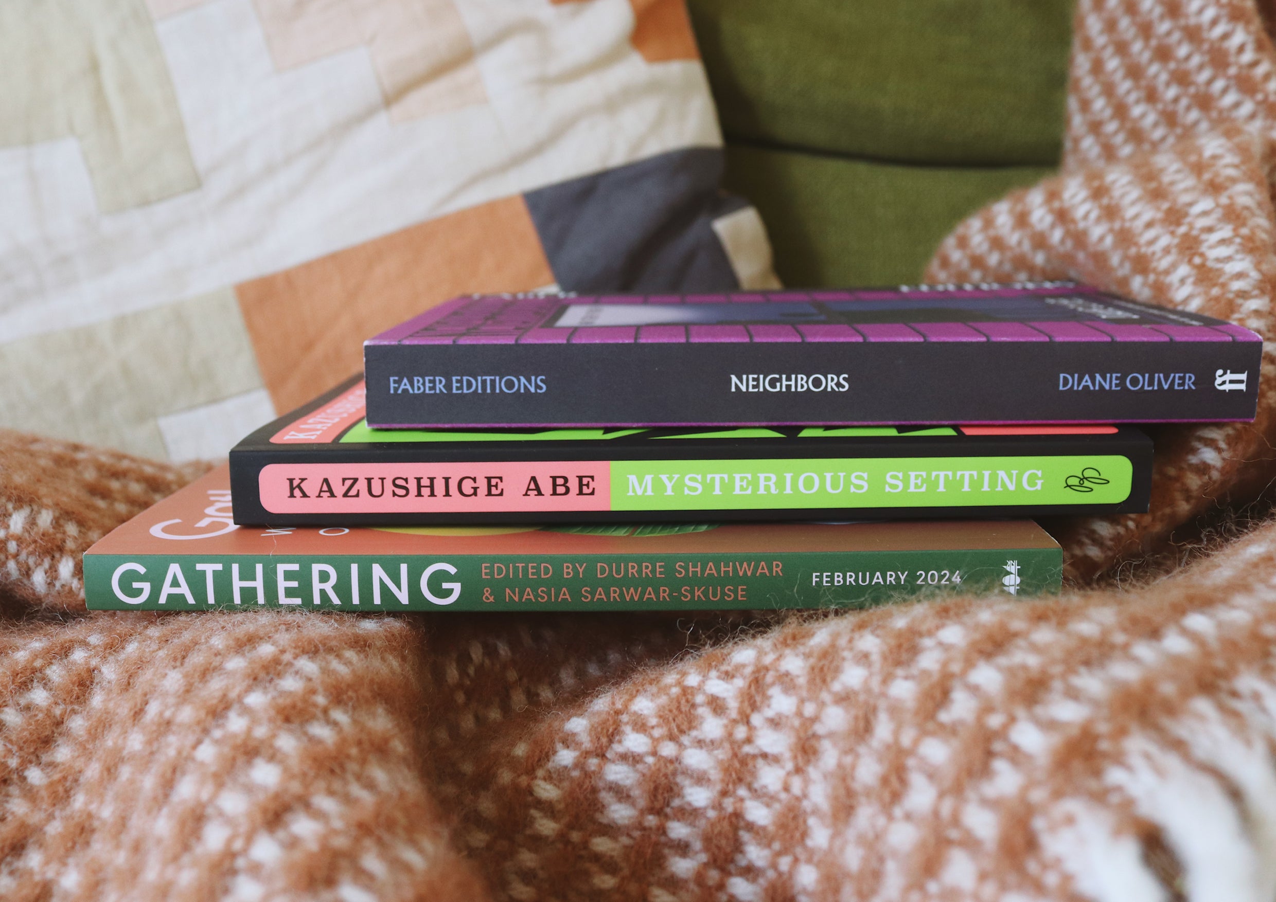 A pile of books on an orange and white blanket