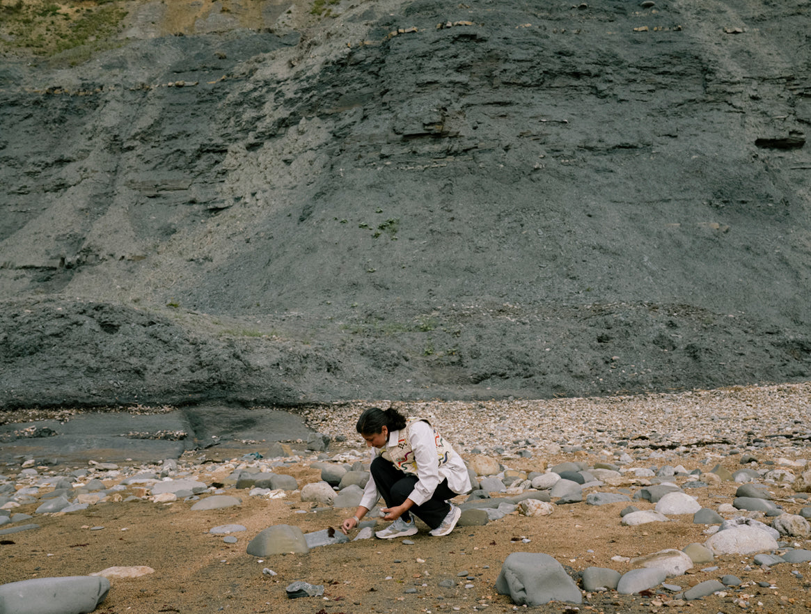 Earth scientist Anjana Khatwa looking at rocks on a Dorset beach