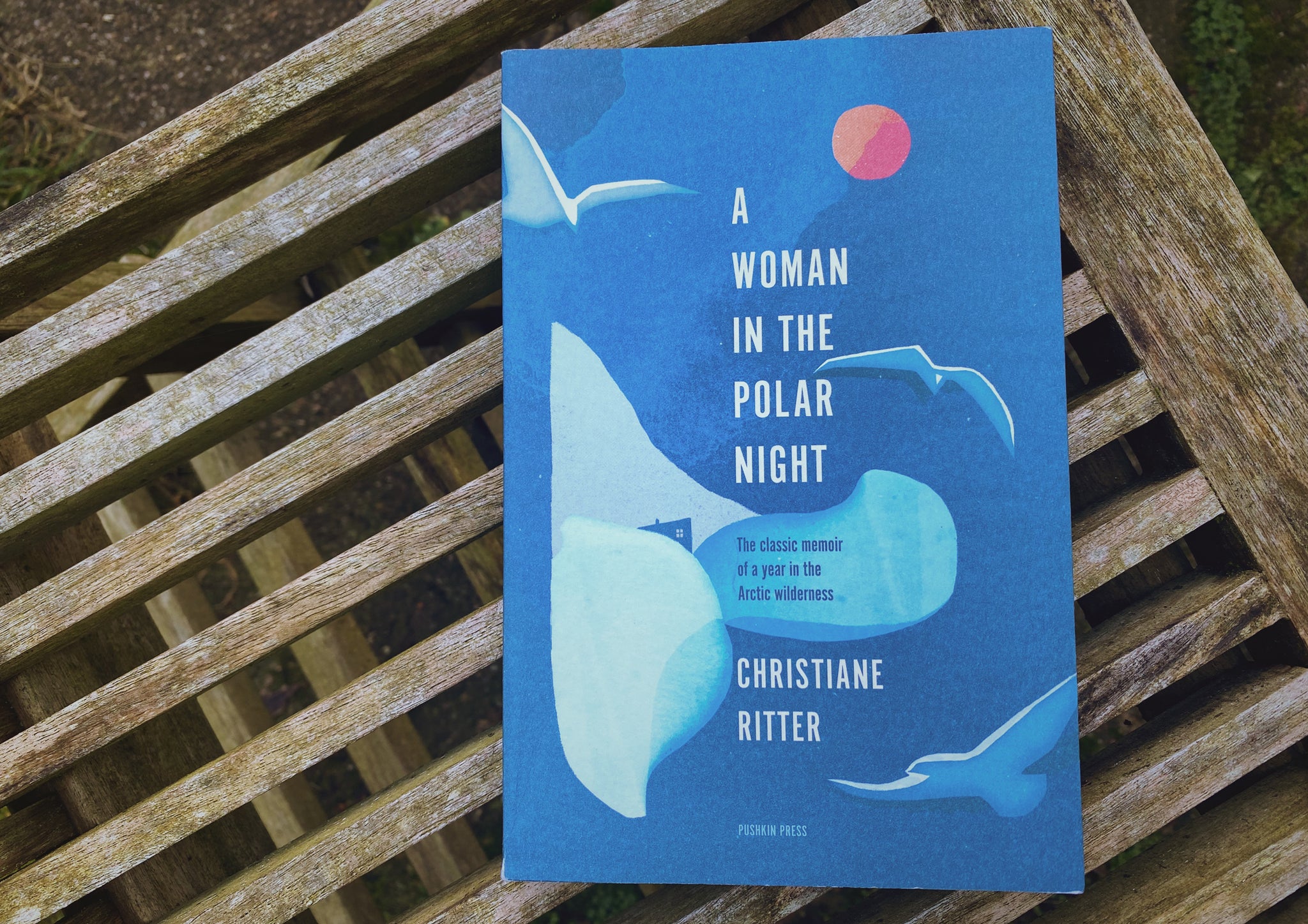 A blue book on a wooden bench